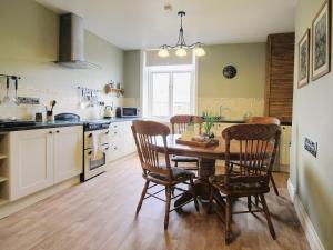 a kitchen with a wooden table and chairs and a kitchen with a window at Brams View in Whitby