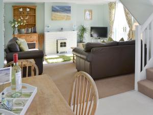 a living room with a couch and a table at Aidan Cottage in Craster