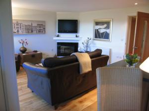 a living room with a couch and a fireplace at Burrow Meadows in Casterton