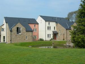 a row of houses with a pond in a yard at Burrow Meadows in Casterton