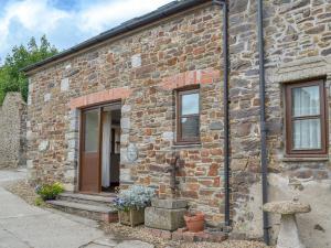 a brick building with a door and windows at Apple Tree Cottage -18512 in Kilkhampton