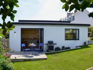 a white house with two chairs and a table in a yard at Bosuns in Port Isaac