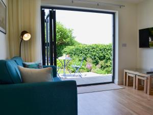 a living room with a large glass door leading to a patio at Bosuns in Port Isaac