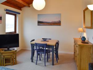 a dining room with a table and chairs and a television at Ffestiniog View in Porthmadog