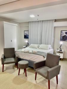 una camera da letto con un letto grande e due sedie di Modelos 501 e 705 Diamond Flats a São Lourenço