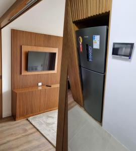 cocina con nevera negra y TV en Apartamento Inteiro em Gramado Bavária Centro, en Gramado