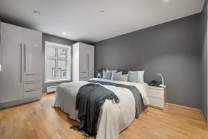 um quarto com uma cama grande e uma janela em Fløyen Lux Apartment em Bergen