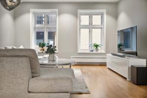 uma sala de estar com um sofá e uma televisão em Fløyen Lux Apartment em Bergen