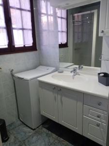 a white bathroom with a sink and a mirror at L'Escale des remparts in Rocroi
