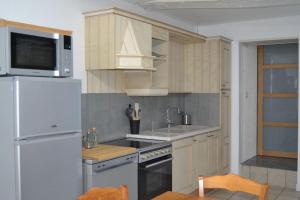 eine Küche mit weißen Geräten und einem weißen Kühlschrank in der Unterkunft L'Escale des remparts in Rocroi