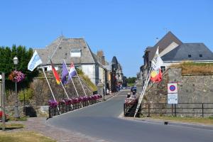 una calle con banderas en un pueblo con casas en L'Escale des remparts, en Rocroi