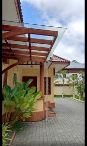 a wooden pergola on a house with a patio at Casa Orchid in Alleppey