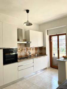 Sunny House في روما: مطبخ بدولاب بيضاء وفرن علوي موقد