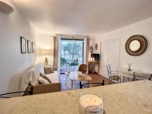 ein Wohnzimmer mit einem Sofa und einem Tisch in der Unterkunft Escale détente - Résidence 4* au sein d'un Golf in Saumane-de-Vaucluse