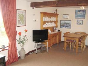 a living room with a television and a dining room table at The Granary in Burscough