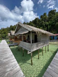 un resort con tetto di paglia su un prato verde di Junior Homestay a Kri