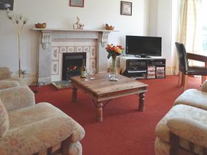 a living room with a coffee table and a fireplace at Welcome Retreat in Newton Abbot