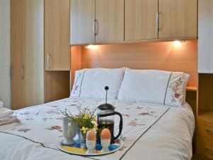 a bed with a tray with two eggs and two cups at Welcome Retreat in Newton Abbot
