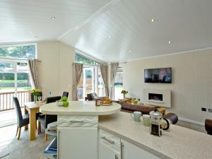 a kitchen and living room with a table and chairs at Forest Glade Lodge in Lanlivery