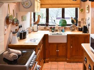 a kitchen with a sink and a stove top oven at Eden Cottage in Cerne Abbas