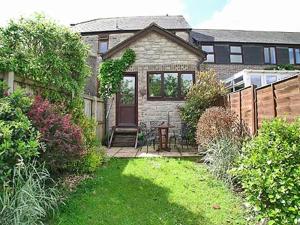 a brick house with a yard with a table in it at Eden Cottage in Cerne Abbas