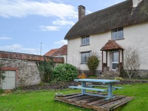a blue picnic table in front of a house at West Hurscott Cottage in Swimbridge