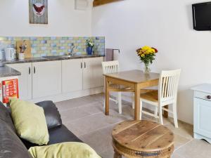 a living room with a table and a kitchen at The Cow Shed in Arlingham