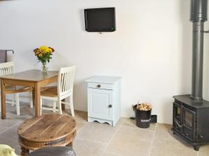 a dining room with a table and a wood stove at The Cow Shed in Arlingham