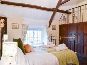 a bedroom with a bed with two pillows on it at West Hurscott Cottage in Swimbridge