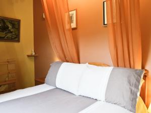 ポート・アッピンにあるWaterside Lodgeのベッドルーム1室(オレンジ色のカーテン付きのベッド1台付)