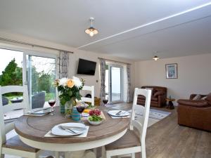 a dining room with a table and chairs and a living room at Orestone Garden Apartment in Dawlish