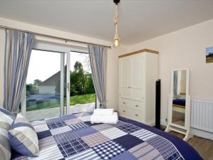 a bedroom with a bed and a large window at Orestone Garden Apartment in Dawlish