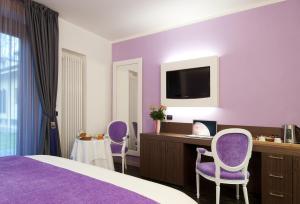 a purple room with a bed and a desk and chairs at Bed&Garden in Cesate