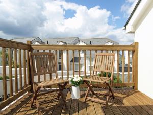 two chairs on a deck with a vase of flowers at Watermark in Saint Columb Minor