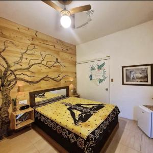 - une chambre avec un lit orné d'une fresque murale sur les arbres dans l'établissement Suite Clorofila House Guest House, à Ubatuba