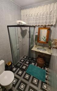 La salle de bains est pourvue d'une douche, d'un lavabo et de toilettes. dans l'établissement Suite Clorofila House Guest House, à Ubatuba