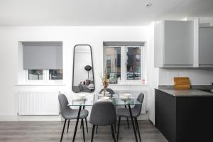 a kitchen with a table with chairs and a mirror at Skyvillion - London Enfield Chase Apartments with Parking & Wifi in Enfield