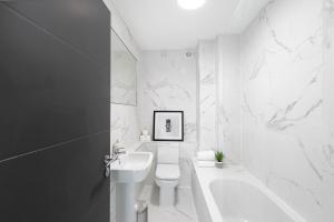 a white bathroom with a sink and a toilet at Skyvillion - London Enfield Chase Apartments with Parking & Wifi in Enfield