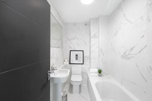 a white bathroom with a sink and a toilet at Skyvillion - London Enfield Chase Apartments with Parking & Wifi in Enfield +119 photos