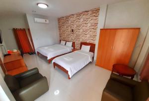 楠府的住宿－潘提普酒店，小房间设有两张床和椅子