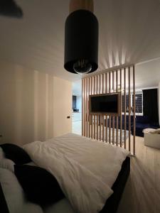 1 dormitorio con 1 cama blanca grande y TV en Апартаменти центр Чортків en Chortkiv