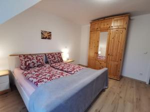 a bedroom with a large bed and a wooden cabinet at Ostseeblick im Andersenhof in Kappeln