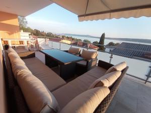 un patio con sofás y una mesa en el balcón en Vila Zdenka Apartmants, en Crikvenica