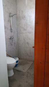a bathroom with a toilet and a shower at BEM VINDOS A KASA in Porto Novo