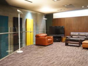 a waiting room with two chairs and a flat screen tv at HOTEL LiVEMAX BUDGET Amagasaki in Amagasaki