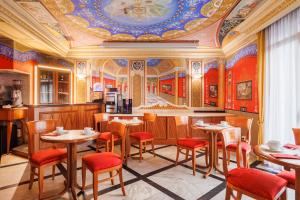 a restaurant with tables and chairs and a ceiling at Hotel Amalfi in Rome
