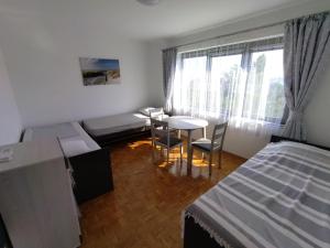 1 dormitorio con 1 cama, mesa y sillas en Vila Zdenka Apartmants, en Crikvenica