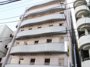 an apartment building with balconies on the side of it at HOTEL LiVEMAX BUDGET Tokyo Kiba in Tokyo