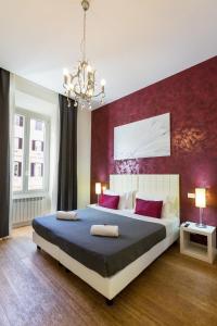 a bedroom with a large bed with a red wall at Residenza Alexander Guest House in Rome