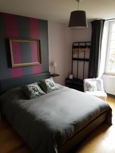 a bedroom with a large bed and a chair at chambres d'hôtes du Tilleul in Nanteuil-en-Vallée +14 photos